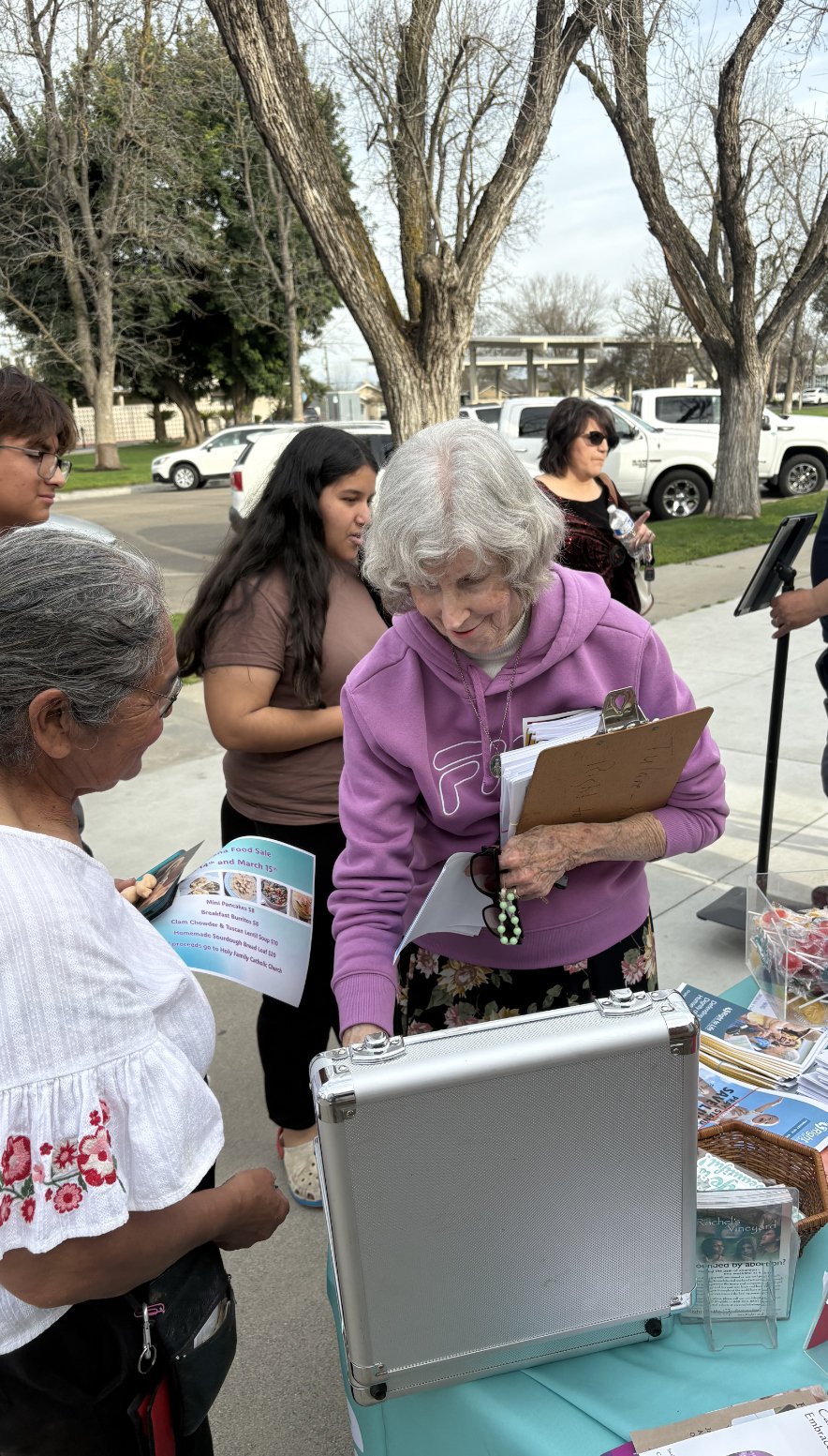 Volunteers welcome visitors at an education booth at the Reedley College health fair