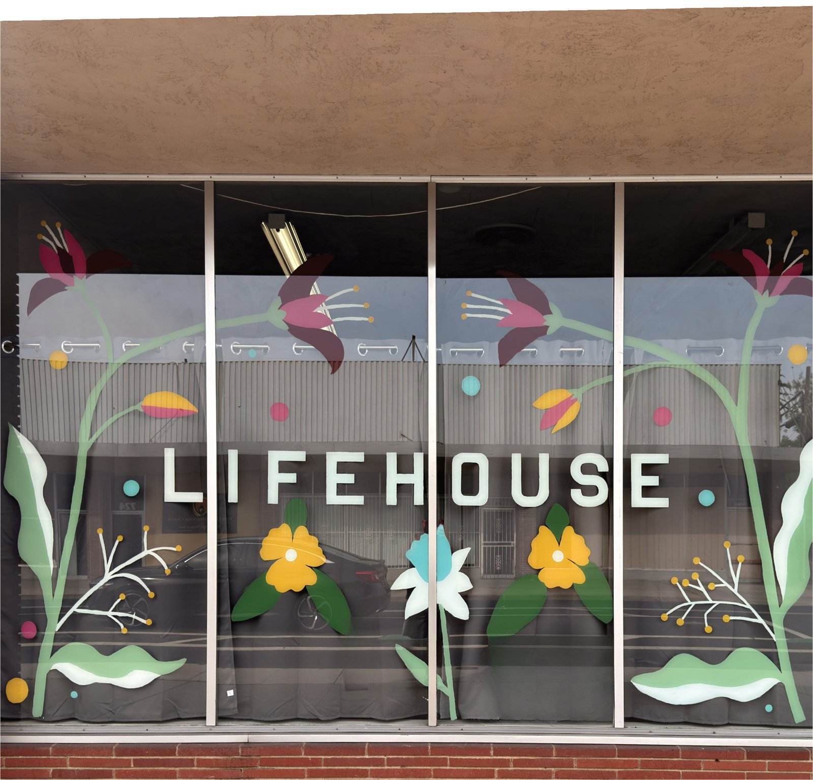 The LIFEHOUSE Outreach Center storefront window painted with flowers