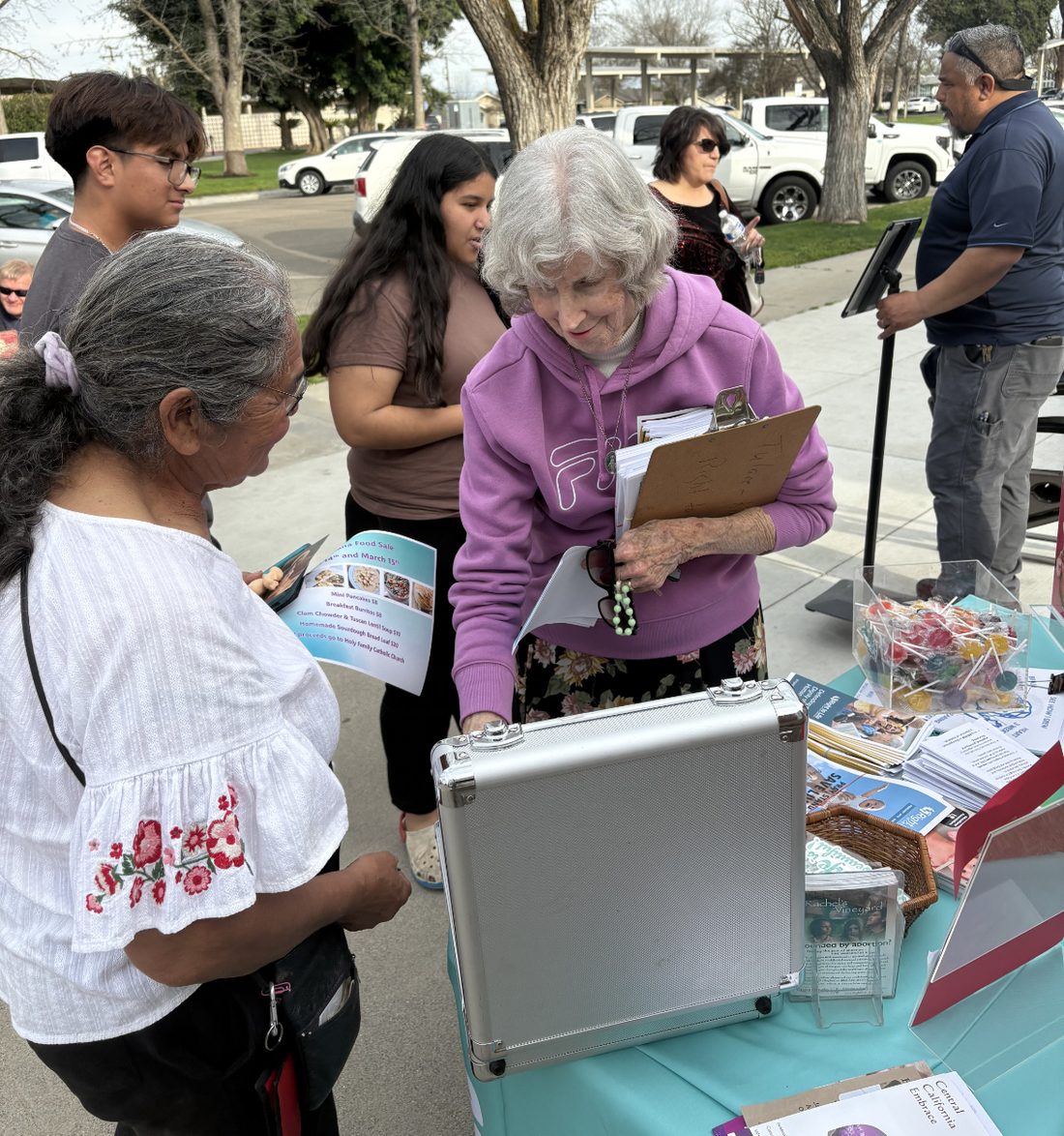 Voluntarios platicando con vecinos en una mesa de alcance comunitario
